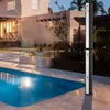 An outdoor shower next to a swimming pool and a house at dusk. Náhľad obrázku produktu