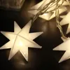 A close-up shot of a string of white star-shaped LED lights. Produktbild-Vorschau