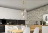 A modern kitchen with white cabinets, a stone accent wall, and a dining table. Náhľad obrázku produktu