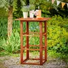 A wooden bar table set up in a garden with plants and drinks. Produktbild-Vorschau