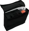 A black fabric bag with a black object and some orange items inside, with the flap open. Produktbild-Vorschau