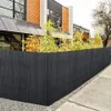 A black PVC privacy fence in front of a modern house with bamboo plants growing behind it. Produktbild-Vorschau