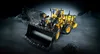 A yellow LEGO Technic Volvo L350F wheel loader is shown in a dark, rocky environment with dramatic lighting. Produktbild-Vorschau