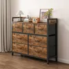 A dresser with seven drawers is shown in a room with wood flooring and a curtained window. Náhled obrázku produktu