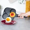 A hand holding a multi-compartment frying pan with a fried egg and a pancake with a strawberry in it. Náhľad obrázku produktu