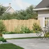 A backyard scene with a raised planter box, a wooden fence, and outdoor furniture. Voir les images du produit