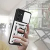 A hand holding a phone case with a ring holder, with a blurred indoor background. Produktbild-Vorschau