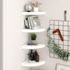 Four white corner shelves are mounted on a light gray wall, displaying various decorative items and books. Voir les images du produit