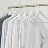Shirts hanging on hangers in a closet. Produktbild-Vorschau