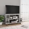 A TV stand with a TV, speakers, and electronic equipment on it, placed in a room with a plant and curtains in the background. Náhľad obrázku produktu