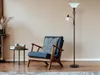 A floor lamp and armchair in a living room setting. Produktbild-Vorschau