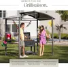 A couple is grilling in a backyard under a gazebo. Produktbild-Vorschau
