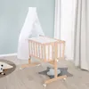 A baby crib with a canopy and bedding, set up in a nursery room. Produktbild-Vorschau
