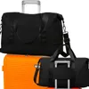 Two black duffel bags are placed on top of an orange suitcase. Voir les images du produit