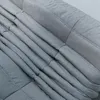 A close-up view of a gray sofa with a quilted texture. Anteprima dell’immagine prodotto