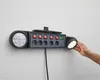 A hand is adjusting a power strip mounted on a white wall. Produktbild-Vorschau