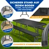 A black folding table and benches set on a grassy lawn, with close-up insets showing the table legs on different surfaces and a carrying handle. Produktbild-Vorschau