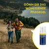 A couple hiking in a scenic landscape with a product bottle in the foreground. Produktbild-Vorschau