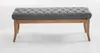 A studio shot of a gray tufted bench with a wooden frame. Náhled obrázku produktu