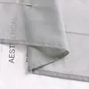 A close-up view of a light gray sheer curtain with text printed on it. Produktbild-Vorschau