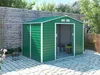 A green garden shed is shown in a backyard setting with a brick wall and paved patio. Náhled obrázku produktu