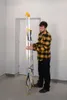 A man is holding a folded aluminum ladder indoors. Anteprima dell’immagine prodotto