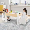 Two young children are playing at a wooden table and chairs set in a brightly lit room. Produktbild-Vorschau