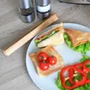 A plate of sandwiches, toast, tomatoes, and bell peppers with salt and pepper grinders in the background. Náhled obrázku produktu