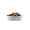 A clear, well-lit studio shot of a small pile of brown, pellet-shaped pet treats in a transparent glass bowl against a plain white background. Produktbild-Vorschau