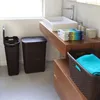 A bathroom scene with laundry baskets and a sink. Produktbild-Vorschau