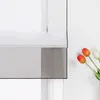 A close-up view of a window with a sheer gray and white Roman blind, and three tulips in the foreground. Produktbild-Vorschau
