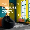 A modern living room with a black beanbag chair, colorful furniture, and large windows. Náhľad obrázku produktu