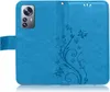 A blue flip case for a smartphone, open to reveal the inside with a floral and butterfly embossed design. Produktbild-Vorschau