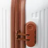A close-up view of a luggage lock and zipper on a white suitcase. Náhľad obrázku produktu