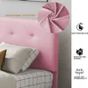 Close-up of a pink upholstered bed headboard with pillows and a detail shot of the fabric. Produktbild-Vorschau