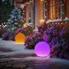 Outdoor scene with snow falling, decorated with colorful lights and glowing spheres. Anteprima dell’immagine prodotto