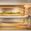 A pizza is being cooked in an oven, with arrows indicating airflow. Produktbild-Vorschau