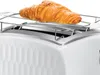 A white Russell Hobbs Honeycomb toaster with a croissant on a warming rack. Podgląd zdjęcia produktu