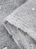 A close-up view of a folded grey fluffy blanket with a star pattern. Anteprima dell’immagine prodotto