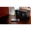 A digital radio and a smartphone are placed on a wooden desk, with books in the background. Produktbild-Vorschau