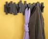 A coat and scarf hanging on a modern coat rack mounted on a yellow wall. Náhľad obrázku produktu