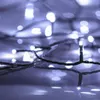 Close-up of white LED string lights on a dark, reflective surface. Produktbild-Vorschau