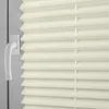 A close-up view of a beige pleated blind with a white window handle. Produktbild-Vorschau