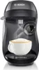 A black Tassimo coffee machine with a cup of coffee on the drip tray. Podgląd zdjęcia produktu