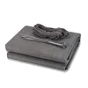 A folded grey fabric privacy screen with a bundle of grey ties and rope on top, set against a white background. Produktbild-Vorschau