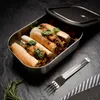 Two sandwiches in a stainless steel lunchbox with a fork and rosemary on a dark surface. Podgląd zdjęcia produktu