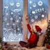 A child in a Santa hat decorates a frosted window with Christmas-themed stickers. Produktbild-Vorschau