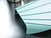 A close-up of a light blue Joseph Joseph Nest Chop cutting board with gray stripes, resting on a metallic surface. Náhľad obrázku produktu