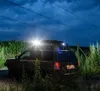A dark, cloudy night scene with a vehicle parked in a field next to power lines. Anteprima dell’immagine prodotto