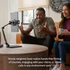 A man and a woman are sitting on a couch, interacting with a tablet mounted on a stand on a coffee table. Produktbild-Vorschau